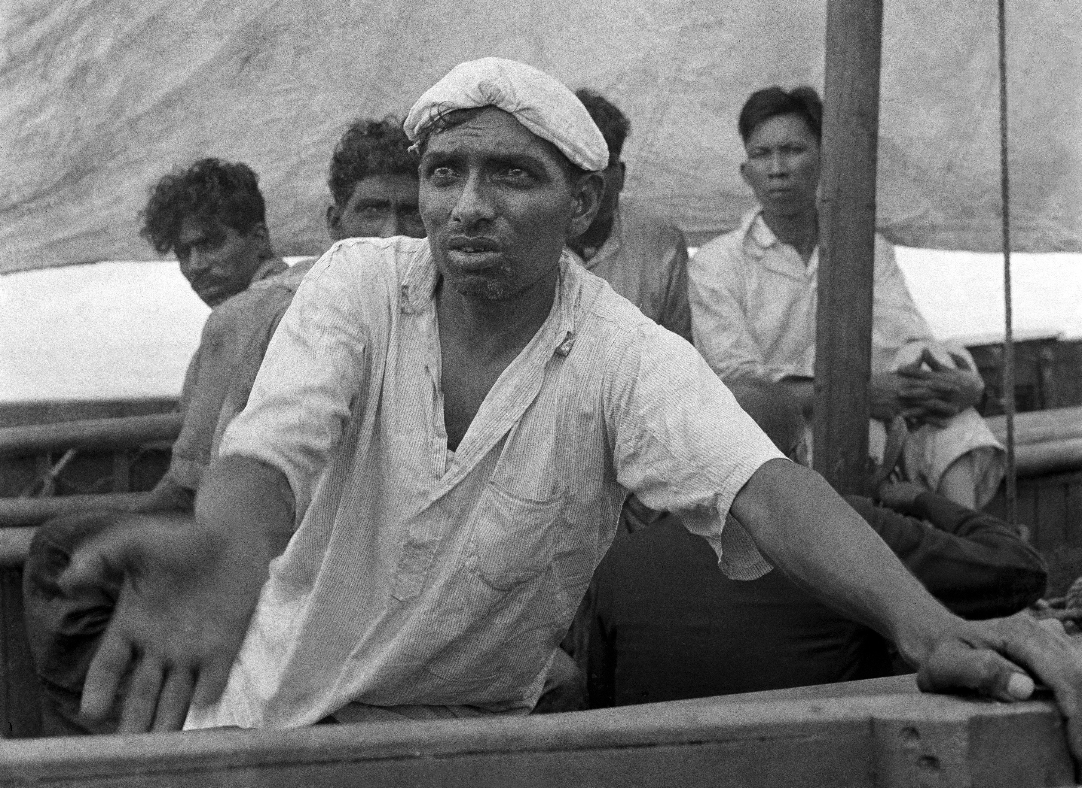  An Indian sailor pleads for water from a lifeboat adrift on the Indian Ocean in January 1942. AP photographer Frank "Pappy" Noel shot this photo from his own lifeboat after a Japanese torpedo sank a ship carrying Noel and others from Singapore. Noel and his fellow survivors eventually reached Sumatra. (AP Photo/Frank Noel)