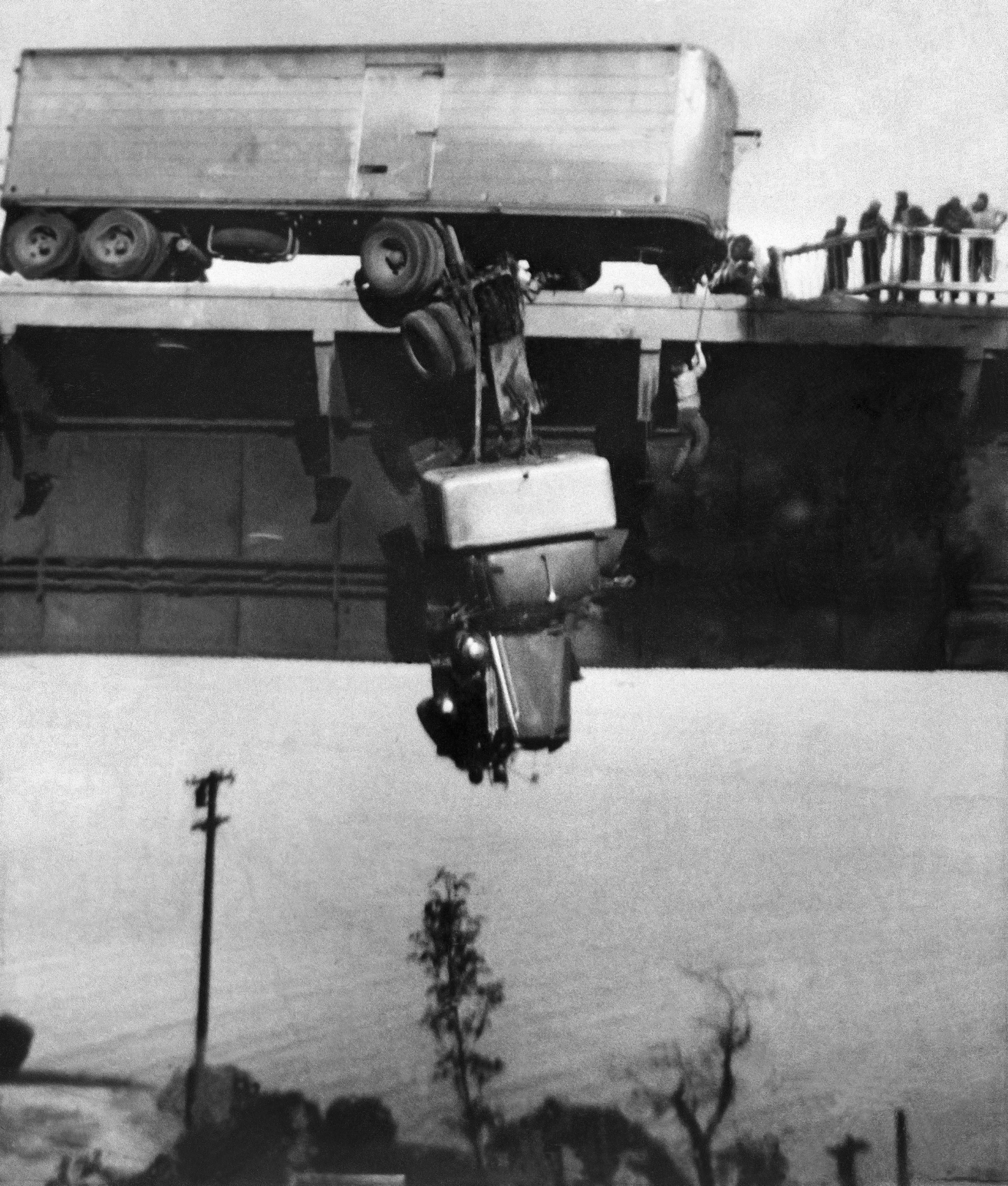 Paul Overby, one of two drivers trapped in the cab of a tractor trailer, is pulled to safety by a rope on the Pit River Bridge across Shasta Lake near Redding, Calif., May 3, 1953. Both Overby and co-driver Hank Baum were rescued before the cab burned and fell to the rocks below. Virginia Schau, an amateur photographer, used a Kodak Brownie camera to shoot the photo. (Virginia Schau via AP)