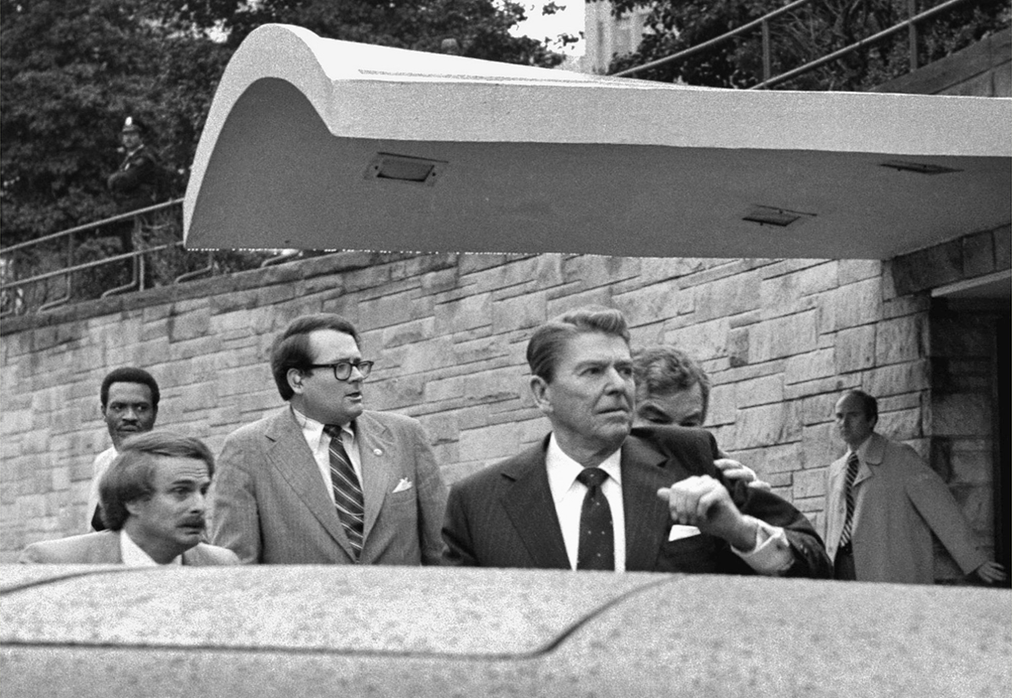 U.S. President Ronald Reagan winces and raises his left arm as he was shot by an assailant as he left a Washington hotel, Monday, March 30, 1981, after making a speech to a labor group. The President was shot in the upper left side. (AP Photo/Ron Edmonds)