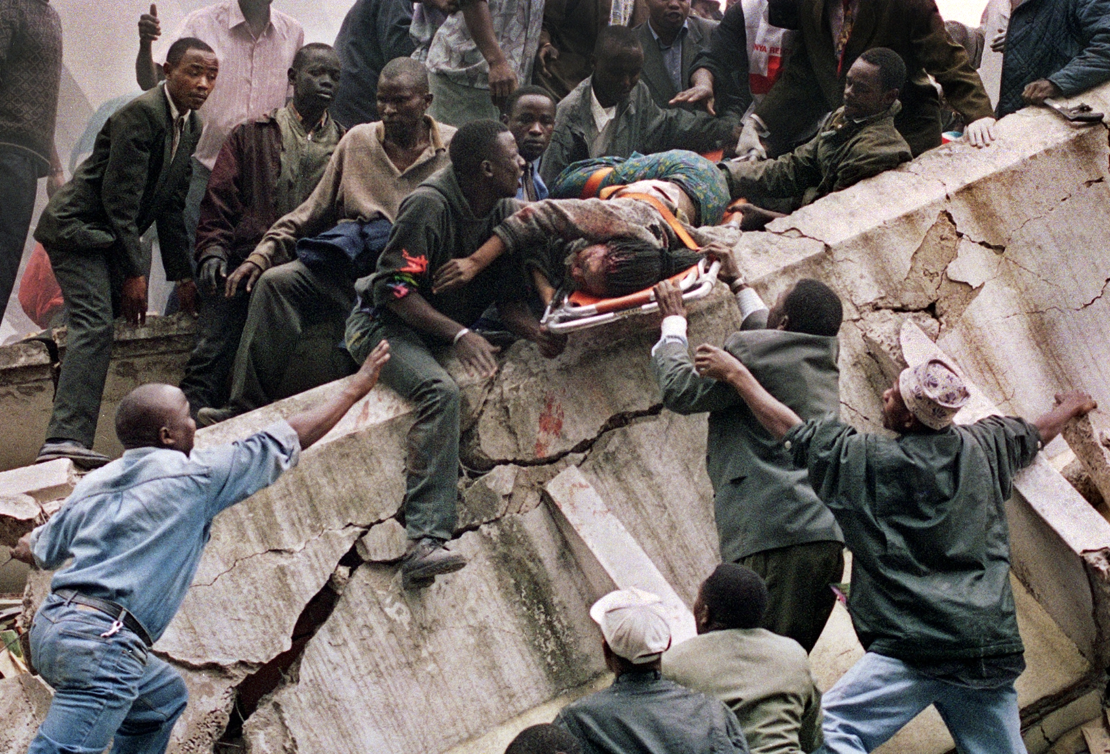 Rescue workers carry Susan Francisca Murianki, a U.S. Embassy office worker, from the rubble of a collapsed building in next to the embassy in Nairobi on Aug. 7, 1998 after terrorist bombs exploded minutes apart outside the U.S. embassies in the Kenyan and Tanzanian capitals. In Nairobi alone more than 200 people were killed and about 4,000 wounded. (AP Photo/Khalil Senosi)