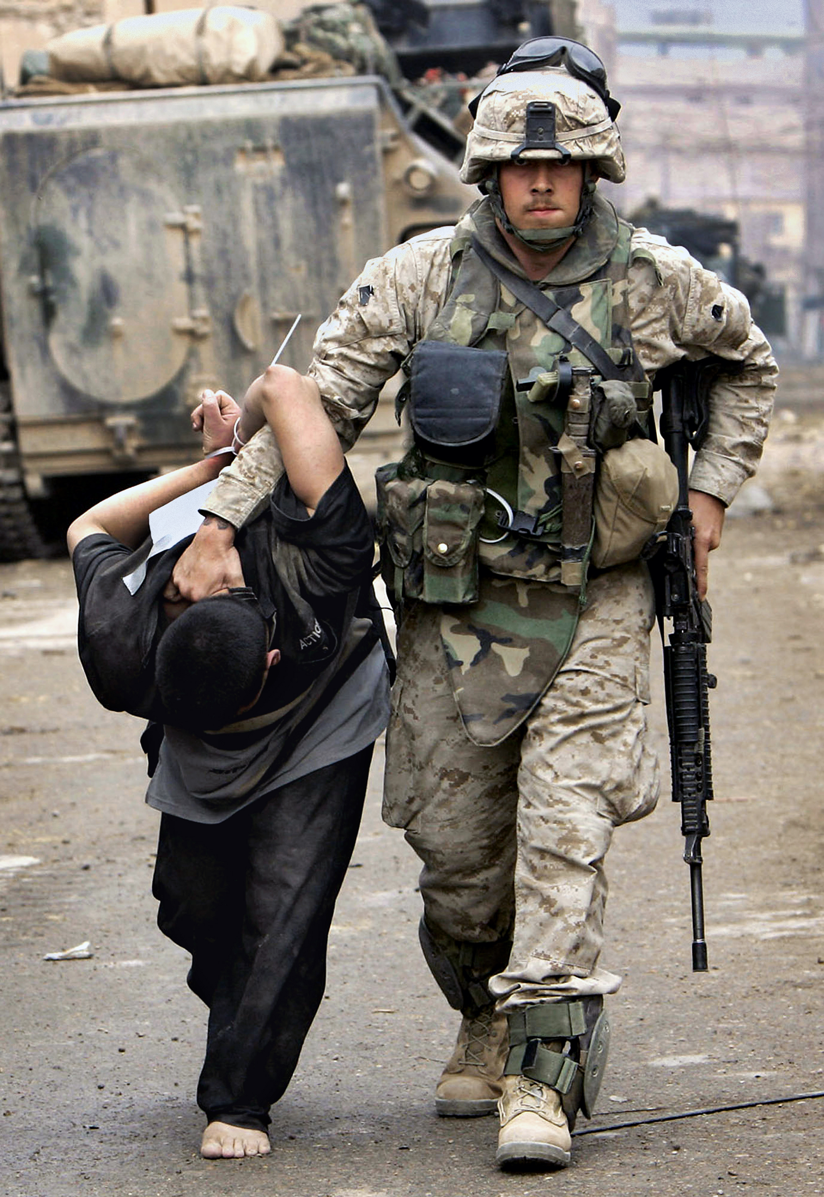 A U.S. Marine leads away a captured Iraqi man in the center of Fallujah, Iraq, Nov. 12, 2004. This photograph is one in a portfolio of twenty taken by eleven different Associated Press photographers throughout 2004 in Iraq. The Associated Press won a Pulitzer prize in breaking news photography, Monday April 4, 2005 for the series of pictures of bloody combat in Iraq. The award was the AP's 48th Pulitzer. (AP Photo/Anja Niedringhaus)