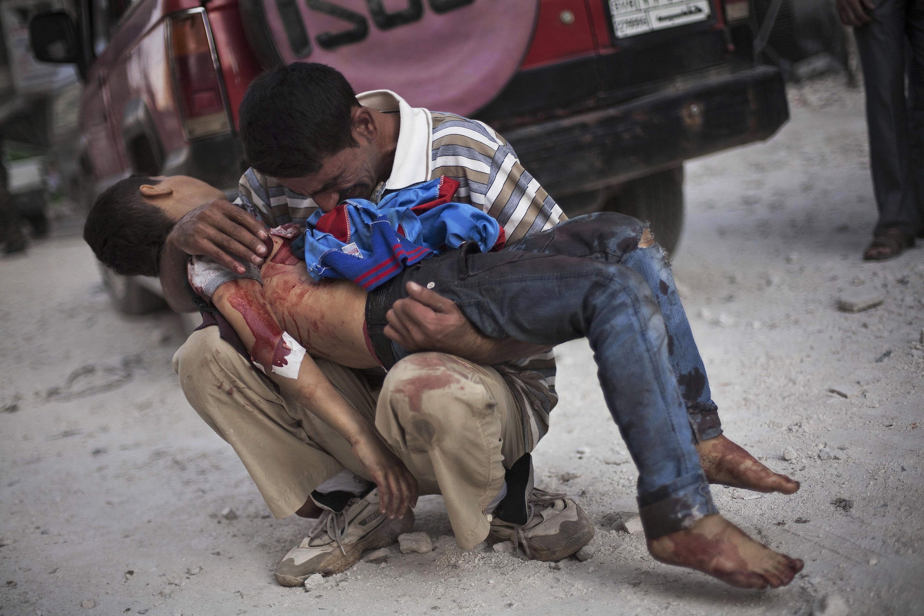 A Syrian man cries while holding the body of his son near Dar El Shifa hospital in Aleppo, Syria, Oct. 3, 2012. The boy was killed by the Syrian army. This image was one in a series of 20 by AP photographers that won the 2013 Pulitzer Prize in Breaking News Photography. (AP Photo/Manu Brabo)