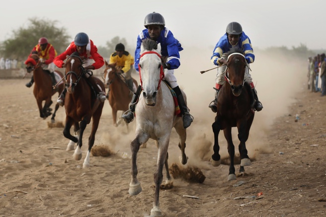 Front vantage point of jockeys riding astride racing horses