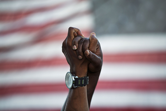 Las manos se unieron frente de la bandera estadounidense